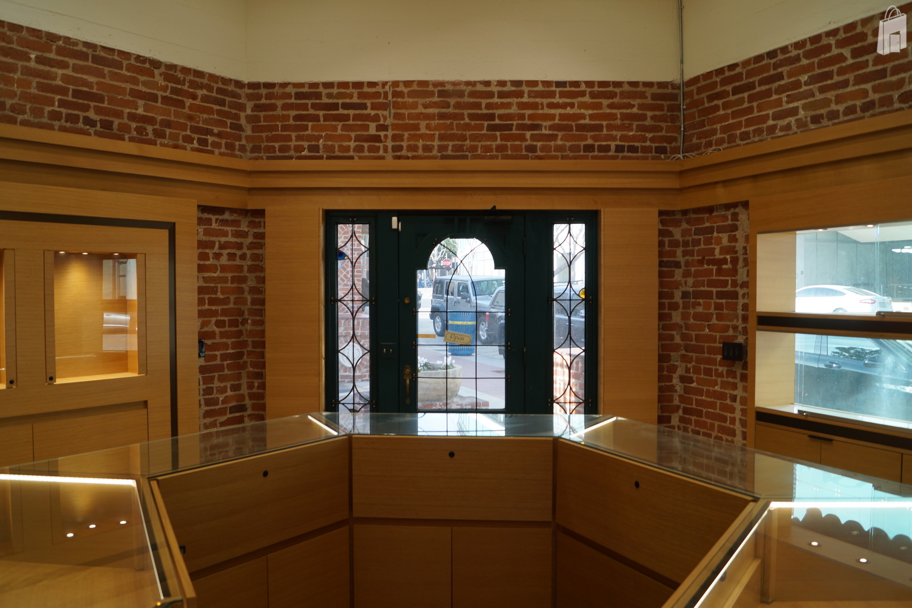 Octogan shaped main retail space with central display and display windows well lit and built into red brick walls.