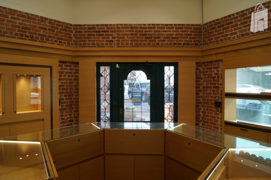 Octogan shaped main retail space with central display and display windows well lit and built into red brick walls.