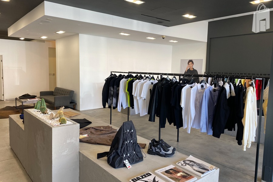 Sales floor feat. clothes racks, display platform and lounge area