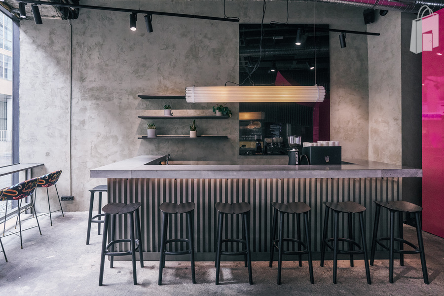 1. Eventlocation München Viktualienmarkt – Barbereich mit Betonwand und modernen Regalen im fancyrosi.studio.